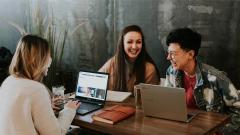 Three people having a meeting with laptops